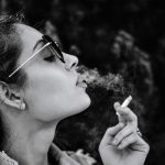 monochrome photo of woman smoking cigarette