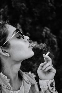monochrome photo of woman smoking cigarette
