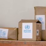 cardboard boxes with world health organization sticker