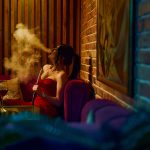 stylish female smoking hookah in bar